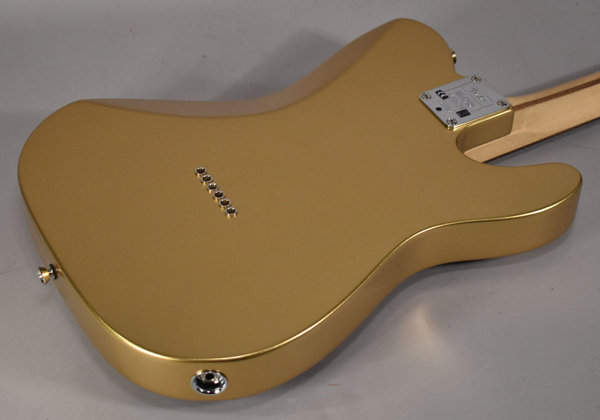 The back of a gold Telecaster with a satin finish, showing six string-through-body ferrules and a chrome output jack.