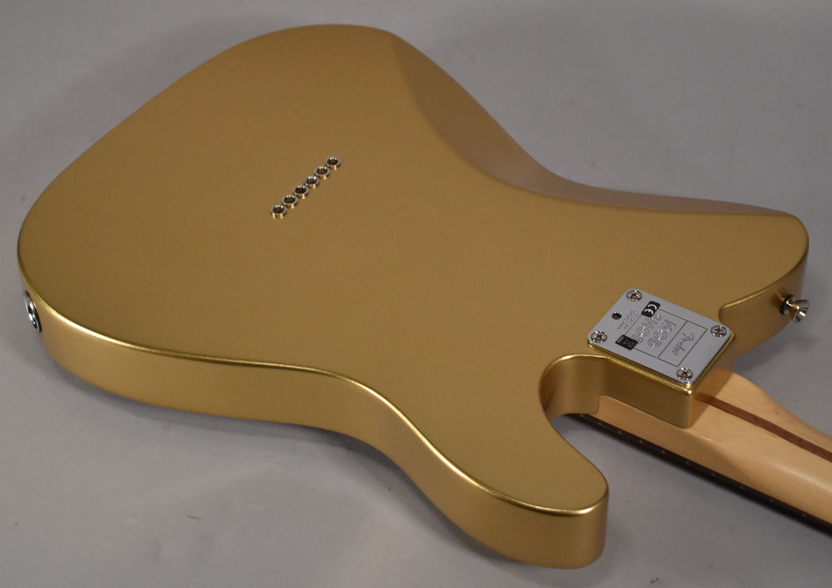 The back of a left-handed gold Telecaster, angled from the lower left, showing string-through ferrules and a neck plate.