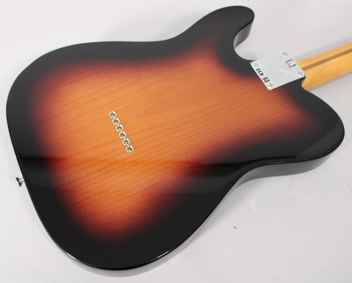 The guitar's glossy 2-color sunburst back, showing six string ferrules and a chrome neck plate, is angled from above.