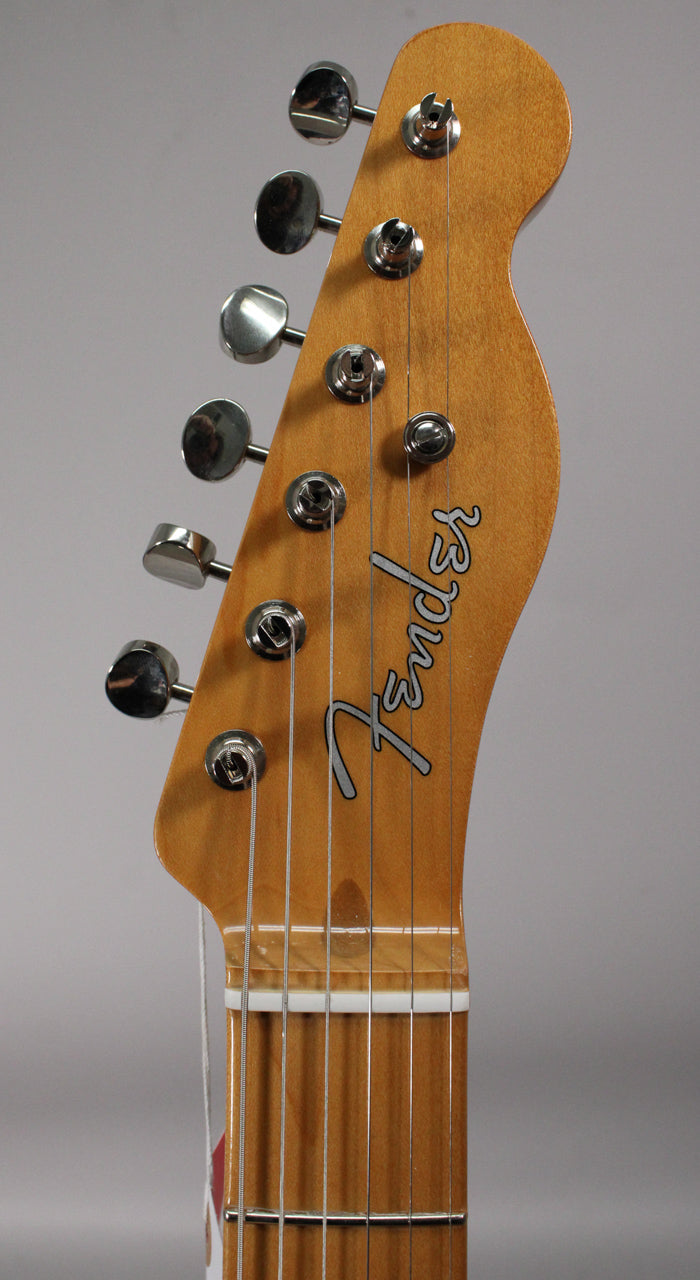 Close-up of the light brown headstock and top of the neck, showing six chrome tuners and the white nut.