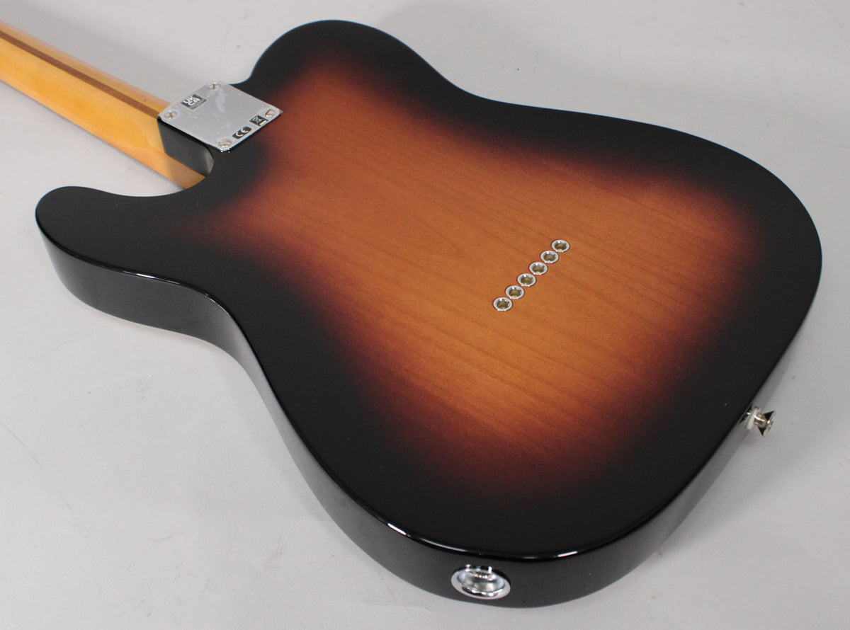 The guitar's back, in a glossy 2-color sunburst, shows six string-through-body ferrules, a chrome neck plate, and a jack socket.