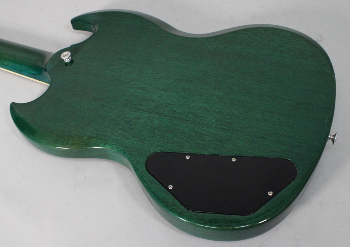 The back of a translucent teal SG guitar, angled from the upper left, showing the wood grain and a black control cavity cover.
