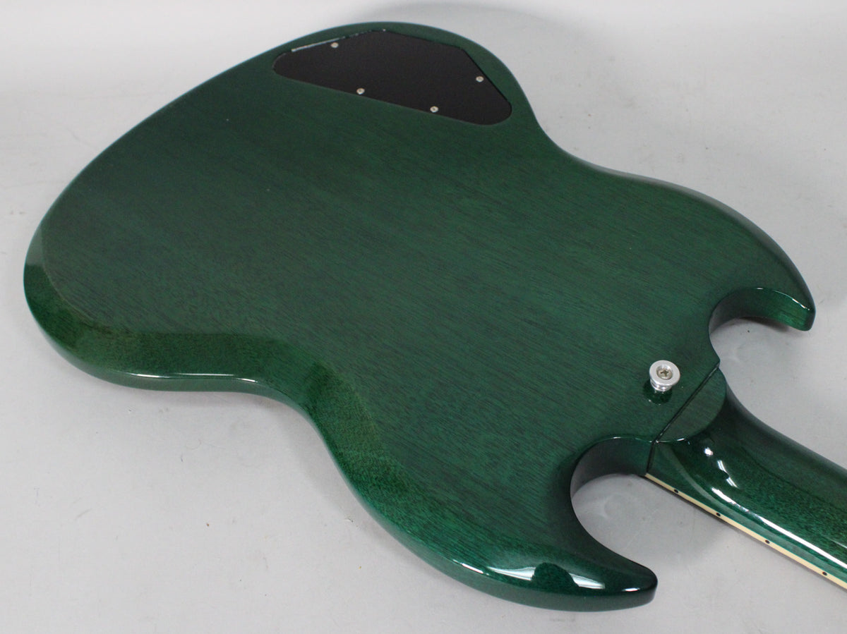 The back of a translucent teal SG guitar, showing the grain, a black control plate, and the neck joint with a strap button.