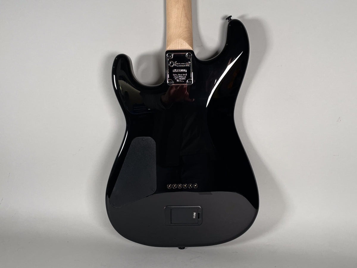 Full rear view of a glossy black guitar body with a natural wood neck, showing the neck plate and a battery compartment.