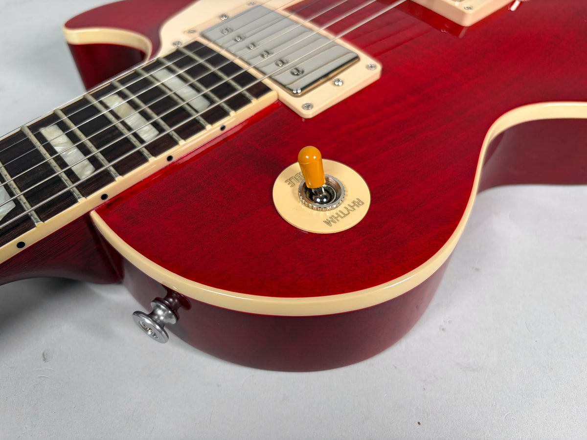 Close-up of the cherry flame top body, showing the cream binding, pickup selector switch, and strap button.