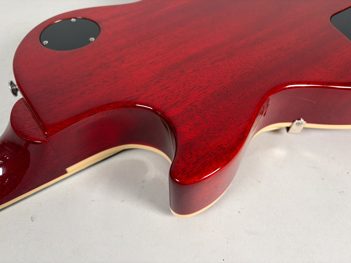 Close-up of the guitar's cherry red back, showing the neck joint, cutaway, and a black control cavity cover.