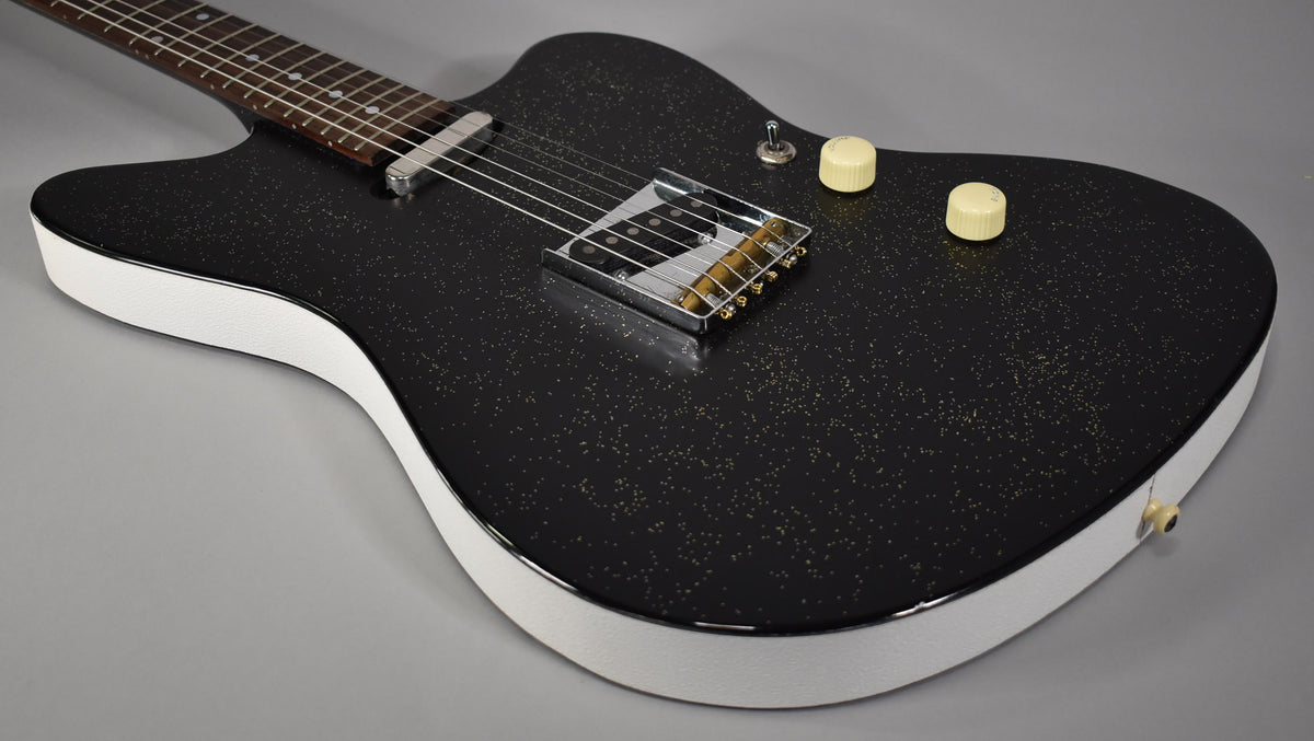 Black sparkle electric guitar, angled from the neck to the lower bout, with white sides, chrome hardware, and two cream knobs.