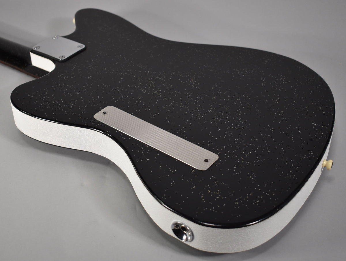 The guitar's black sparkle back and white textured sides are visible, with a chrome neck plate and a ribbed control cover.