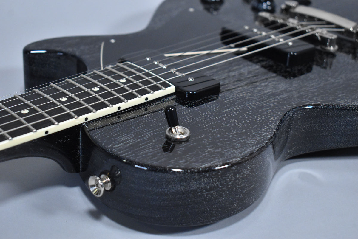 Close-up of the black doghair finish body and fretboard, showing the pickup selector switch and strap button.