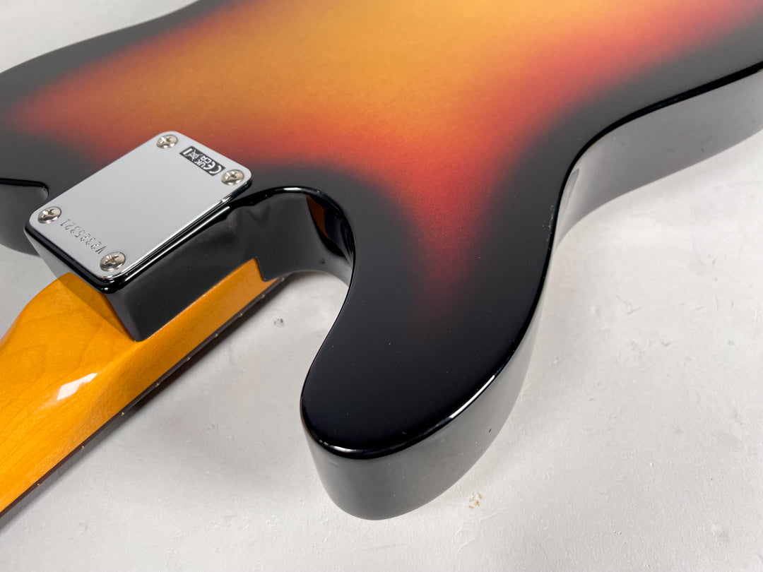 Close-up of the guitar's lower horn and neck joint, showing the glossy sunburst finish and chrome neck plate with visible serial number.
