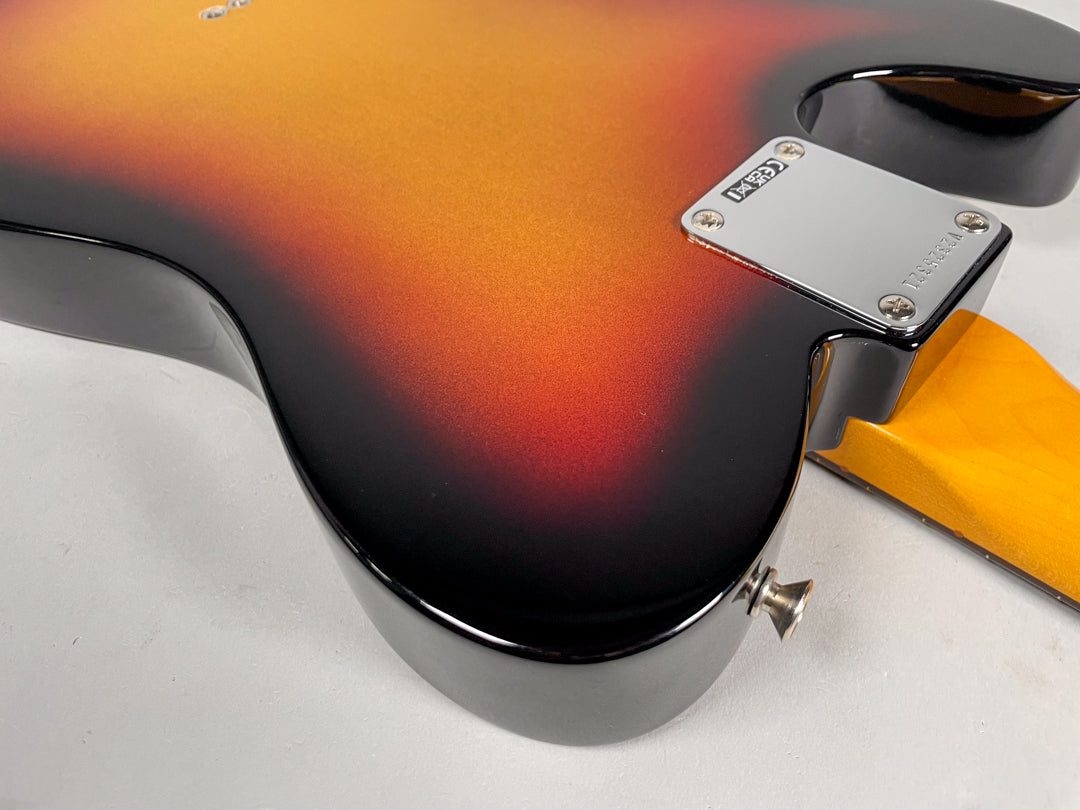 The back of a sunburst Telecaster body, showing the chrome neck plate, strap button, and a glimpse of the maple neck.