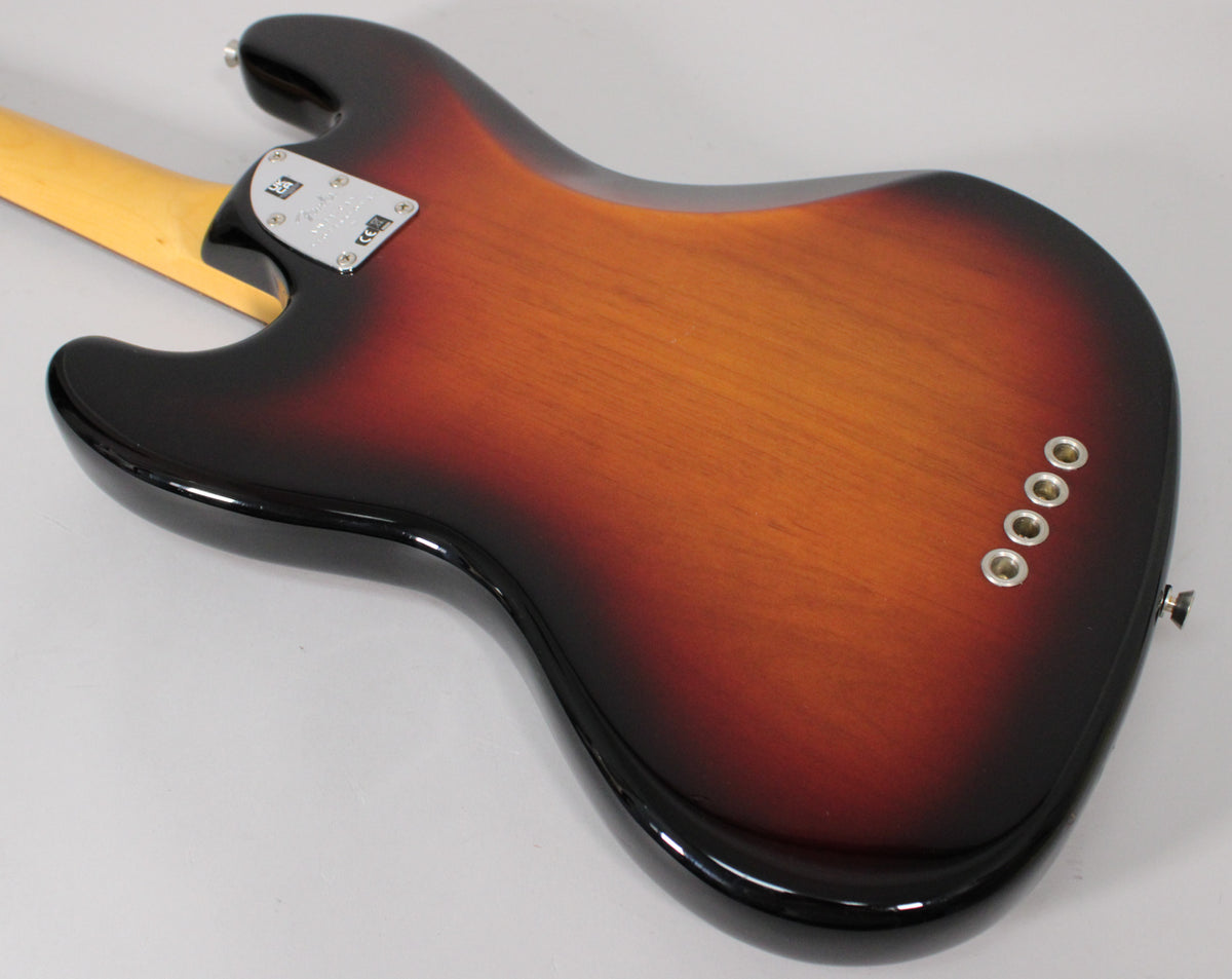 The back of a sunburst bass body, showing the neck plate, four string ferrules, and a strap button.