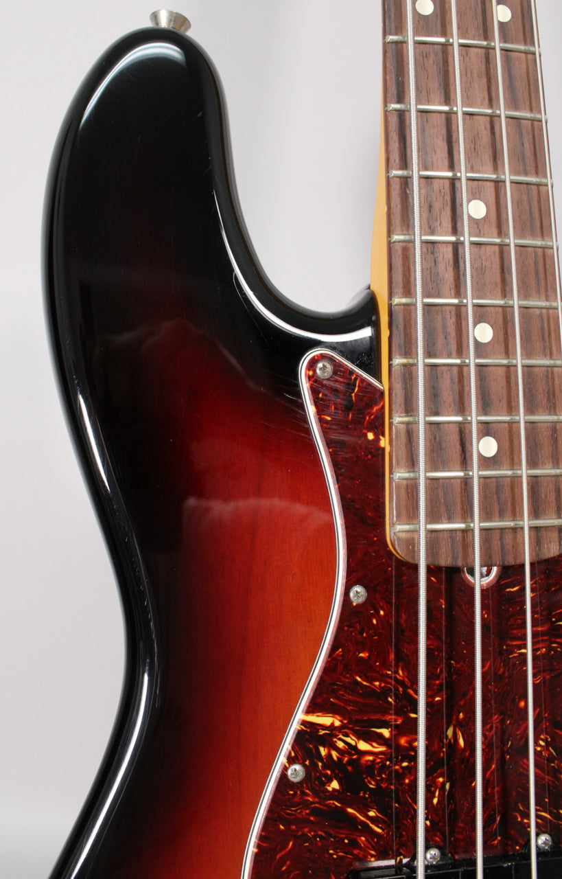 Close-up of the bass body's upper horn and part of the fretboard, showing the 3-color sunburst finish and tortoiseshell pickguard.