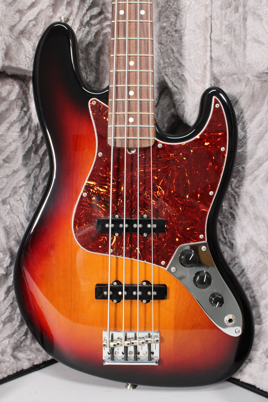 The 3-color sunburst bass is angled slightly, showing its glossy finish, tortoiseshell pickguard, two pickups, and chrome control plate.