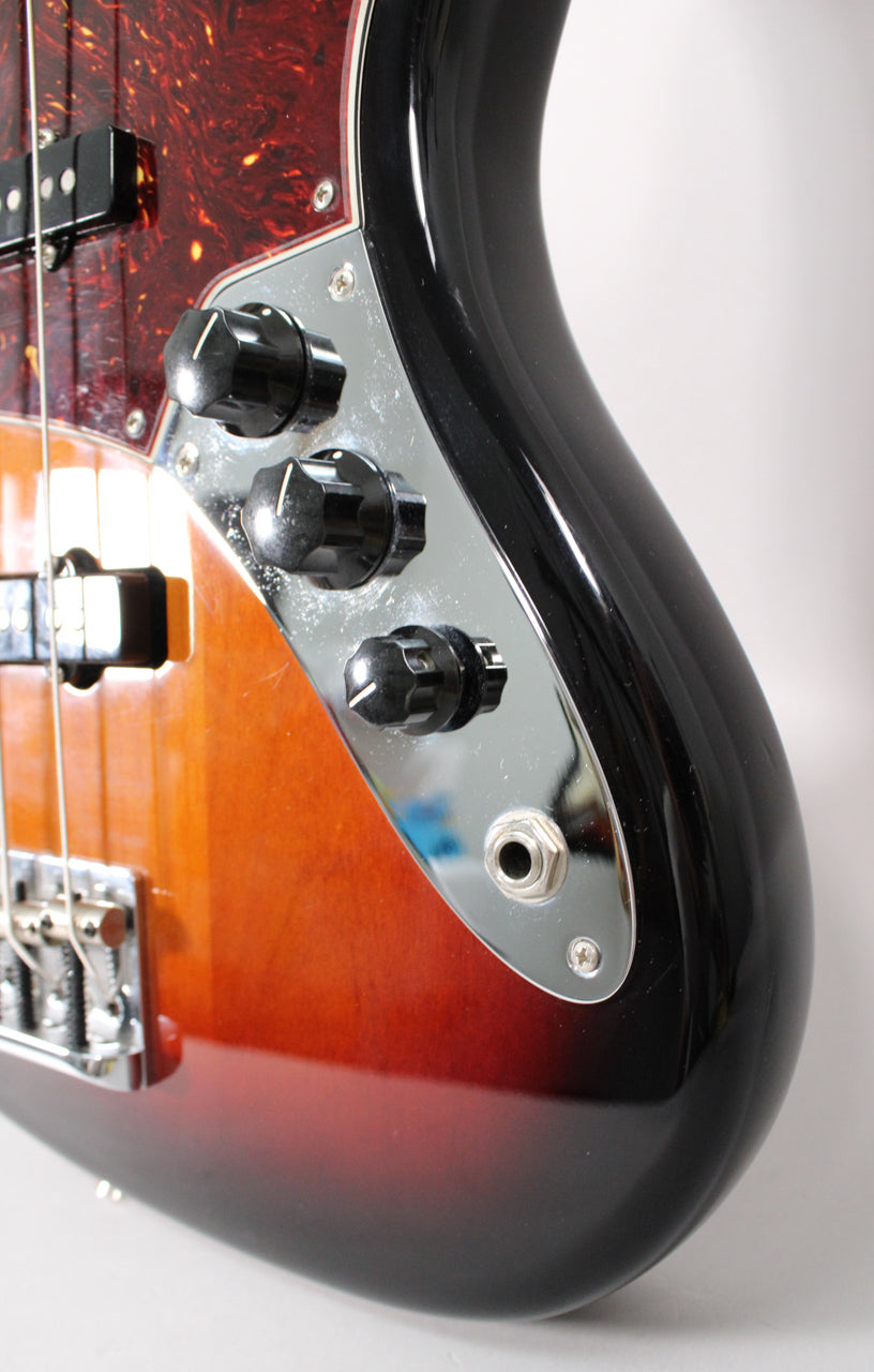 Close-up of the lower body, showing the 3-color sunburst finish, chrome control plate with three black knobs, and output jack.