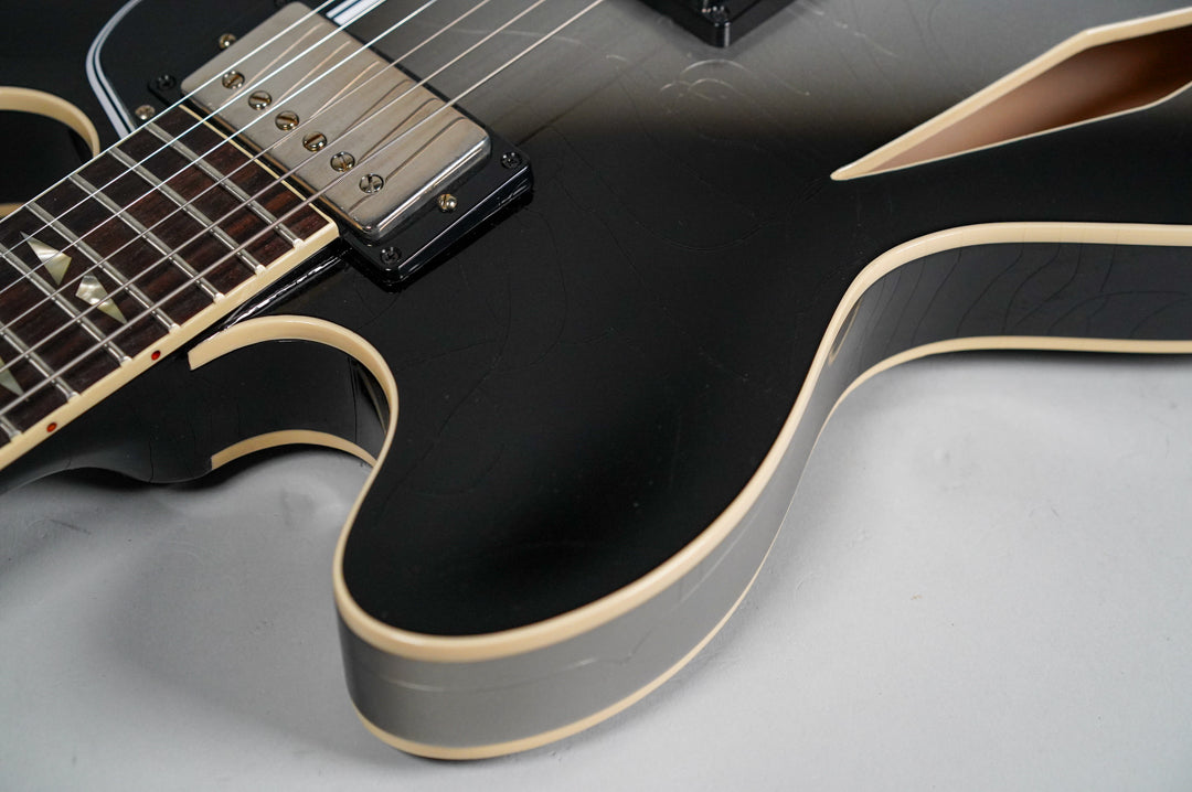 Close-up of the guitar's lower bout, showing the silverburst finish with light aging, cream binding, and a humbucker pickup.