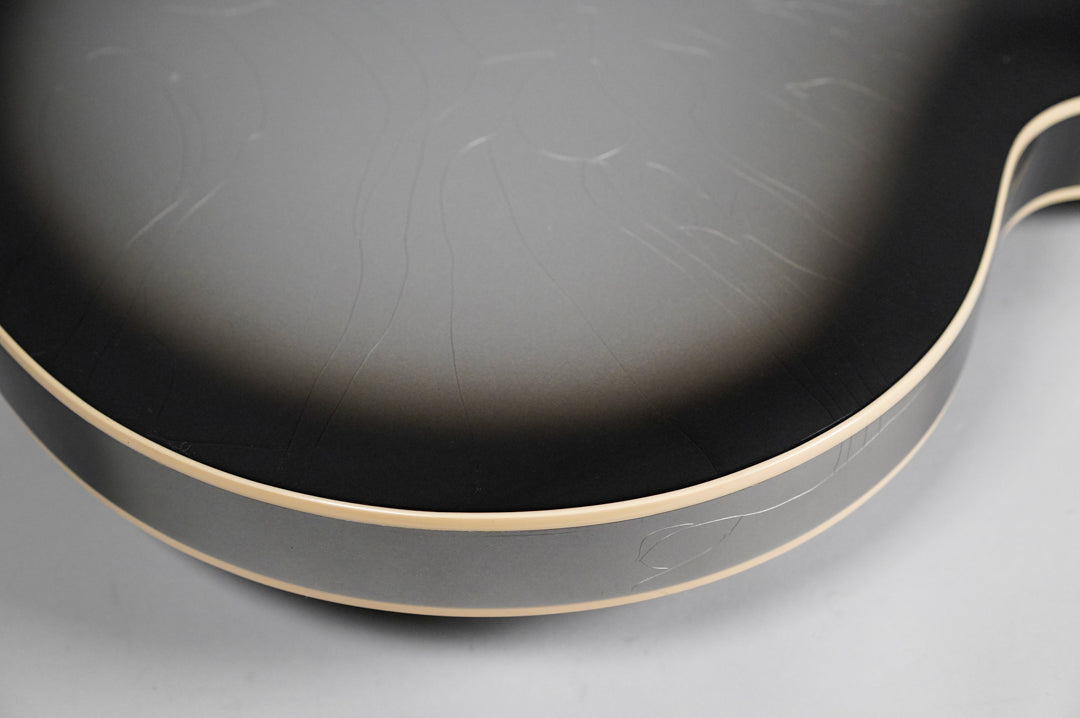 Close-up of the guitar's lower bout, showing the silverburst finish with extensive finish checking and light cream binding.