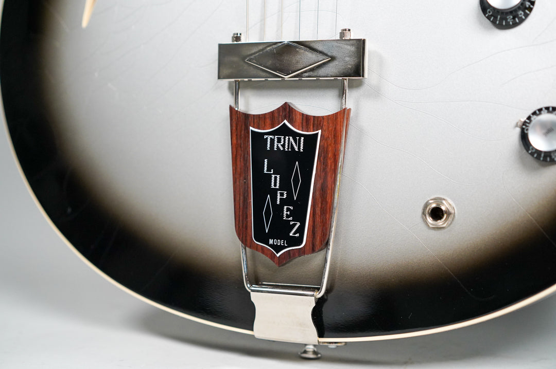 Close-up of the guitar's lower body, showing the silverburst finish with fine checking, a wooden tailpiece, and two control knobs.