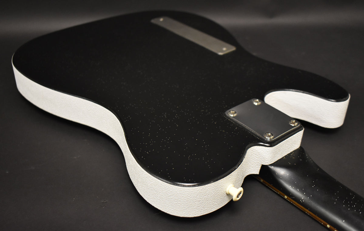 The guitar's black sparkle back and white textured sides are visible, with a cream output jack and neck plate.