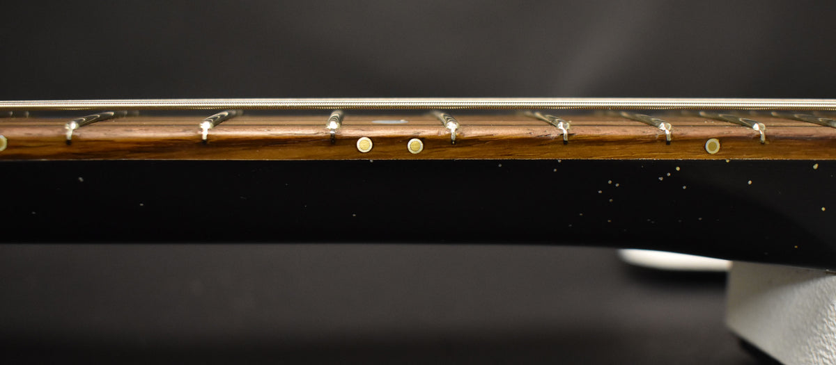 Close-up of the guitar's dark sparkle finish neck, showing the rosewood fretboard with round side dots and fret wires.