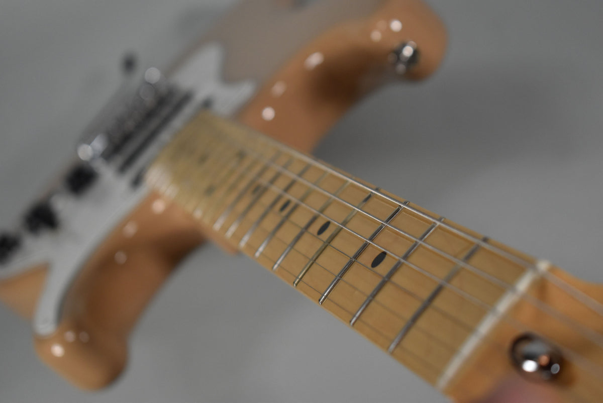 Close-up of the Sahara Taupe Stratocaster's maple fretboard with black dot inlays, angled from the headstock towards the body.