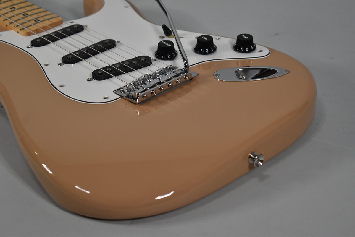 Upper body of a Sahara Taupe Stratocaster, showing the glossy finish, white pickguard, three black single-coil pickups, and chrome hardware.