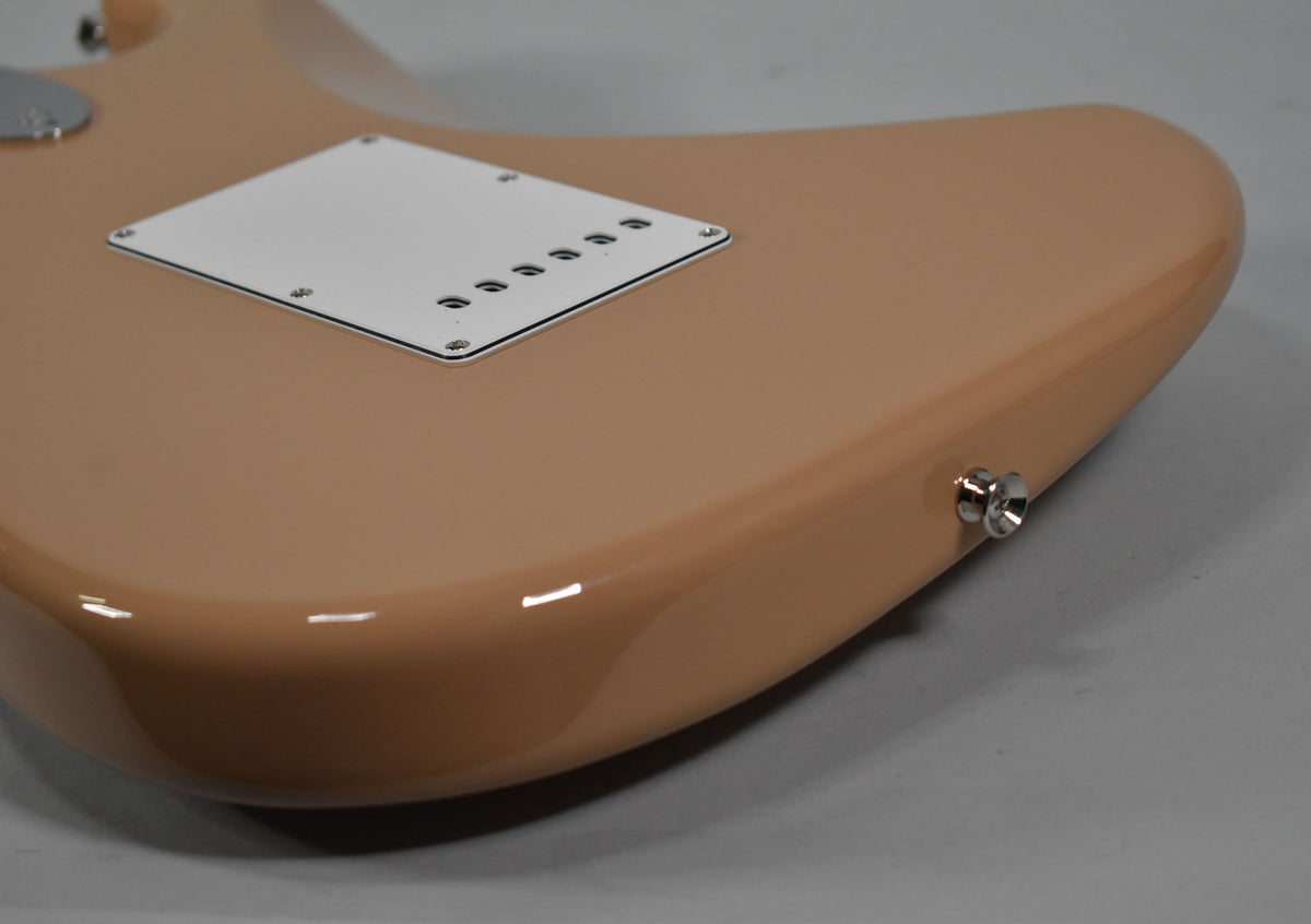 The Sahara Taupe Stratocaster's glossy back shows a white tremolo cover with six holes and a chrome strap button.