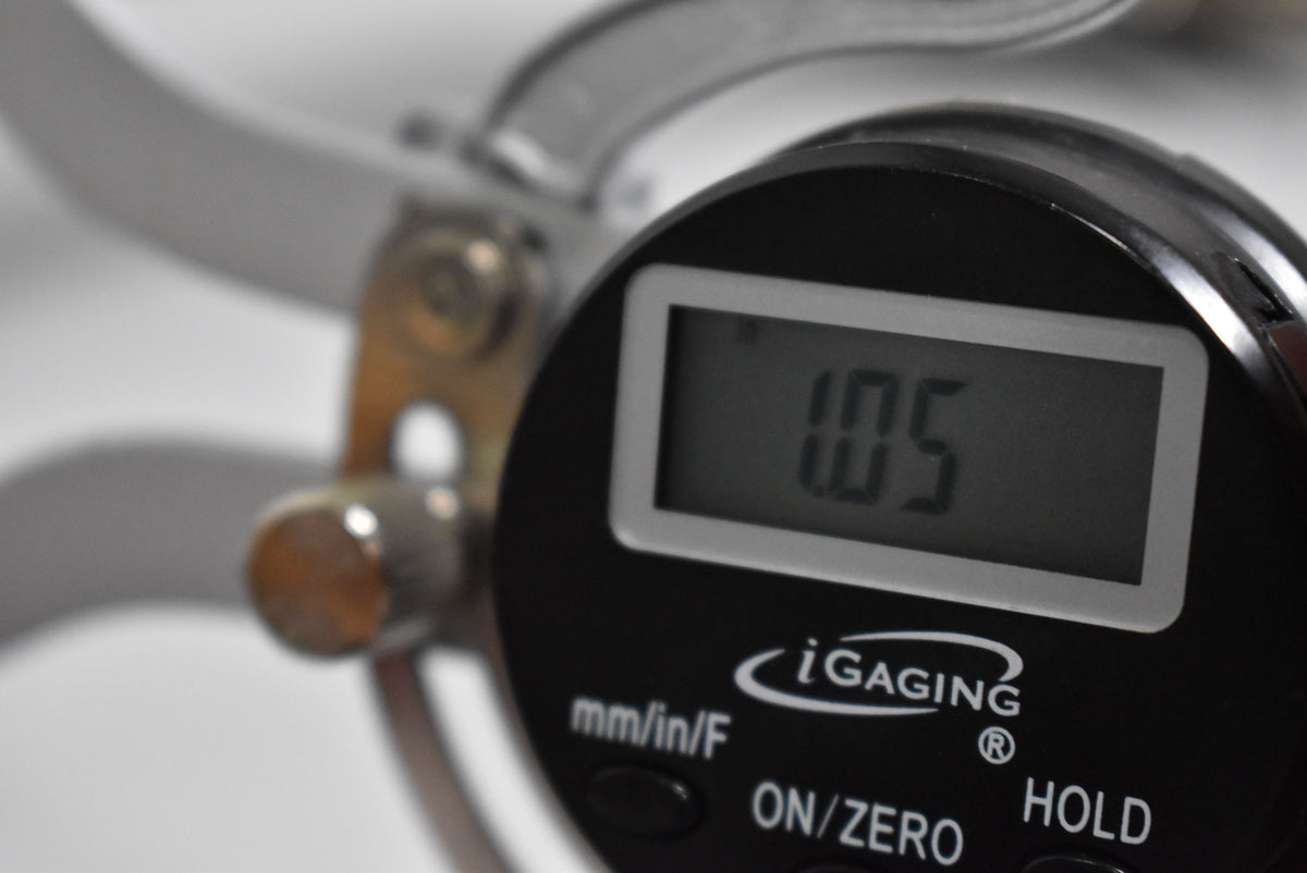 A close-up of a digital caliper showing a reading of "1.05" on its screen.