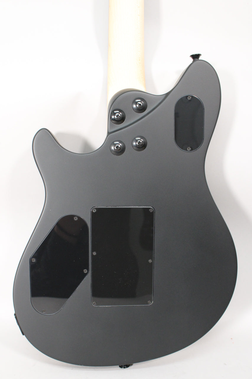 The back of a matte black electric guitar, showing the neck joint, control cavity covers, and strap button.