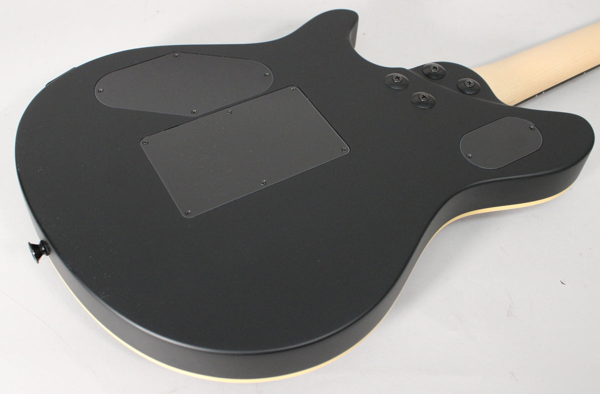 The guitar's matte black back shows three control cavity covers, four black neck bolts, and a light-colored binding around the body.