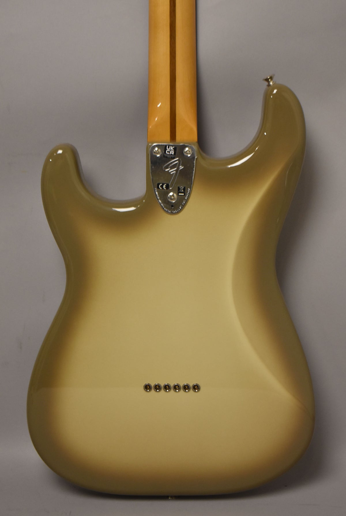 The guitar's back, showing a glossy Antigua finish with a light center fading to dark edges, a maple neck, and six string-through-body ferrules.