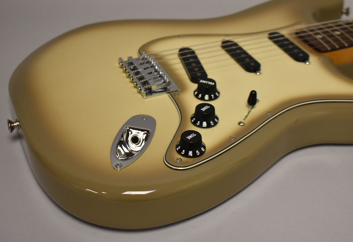 The Antigua Stratocaster's lower body, showing the output jack, three black control knobs, and the chrome tremolo bridge.