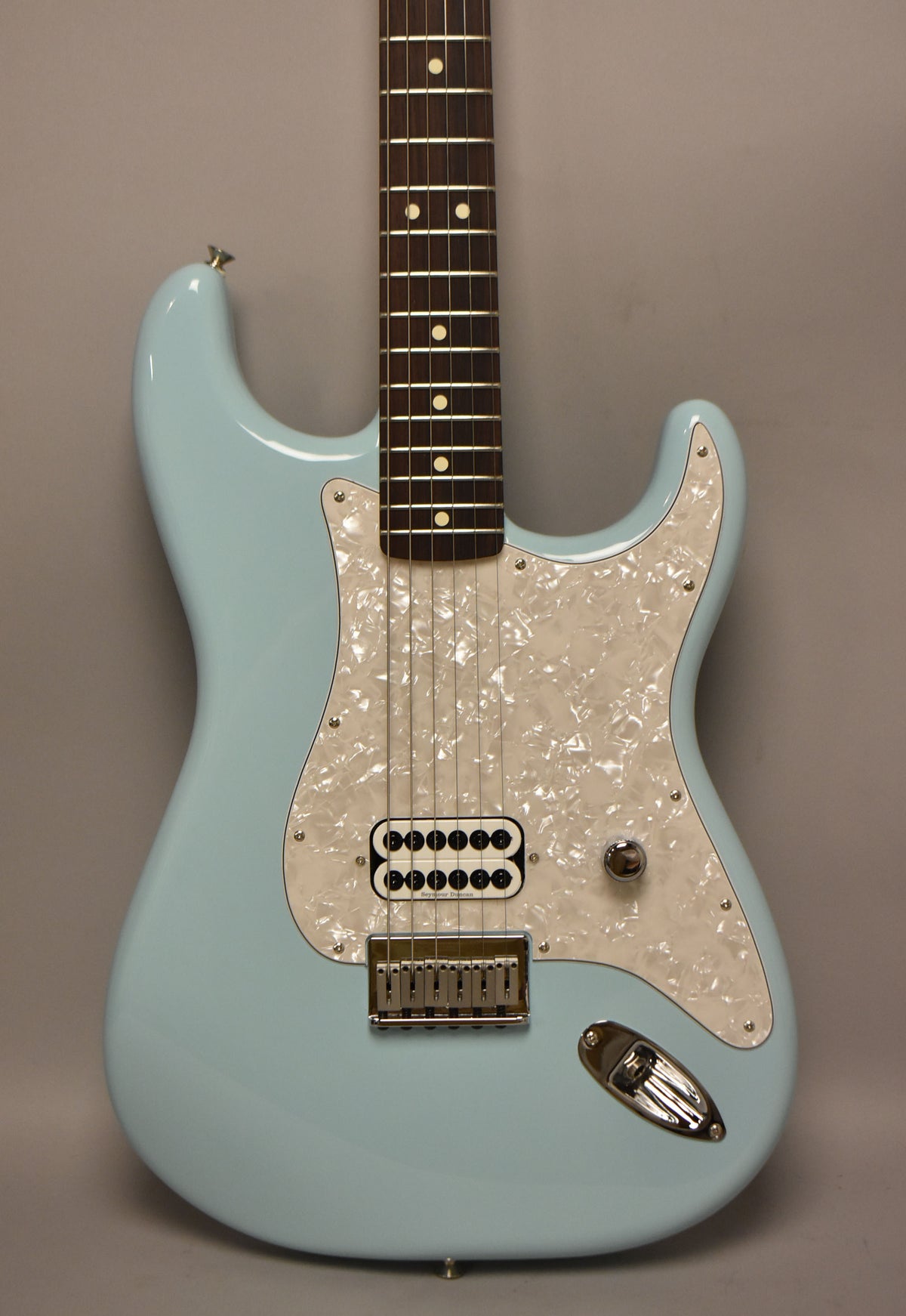 Full-frame, glossy Daphne Blue Stratocaster with a pearloid pickguard, single humbucker pickup, and chrome hardtail bridge.