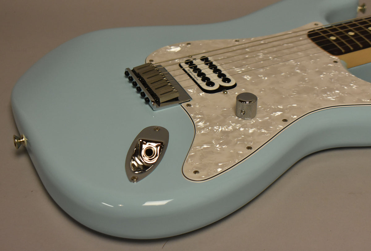 Close-up of the Daphne Blue body, showing the pearloid pickguard, chrome bridge, single humbucker, and knurled volume knob.