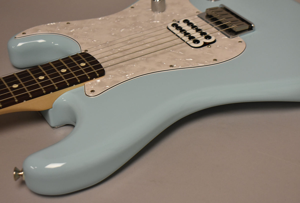 Close-up of the Daphne Blue Stratocaster body, showing its pearloid pickguard, single humbucker pickup, and a single chrome control knob.