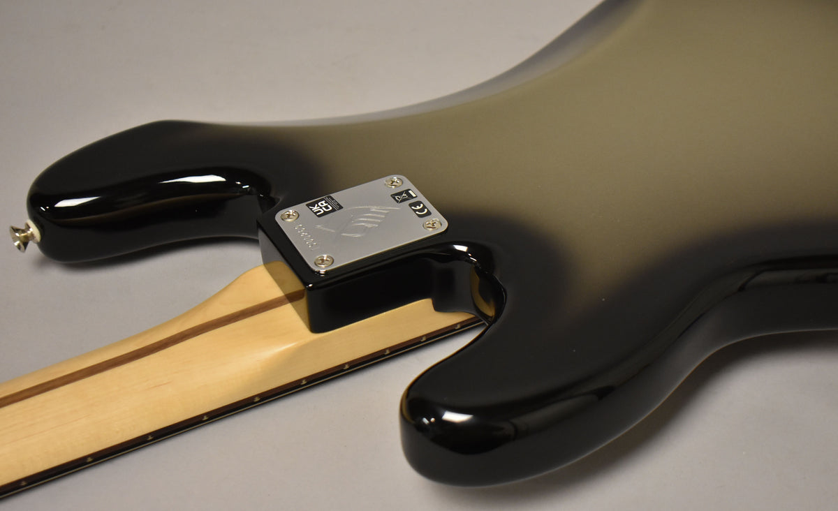 Rear view of the bass body in glossy silverburst, showing the neck joint with a silver rectangular plate and a light wood neck.
