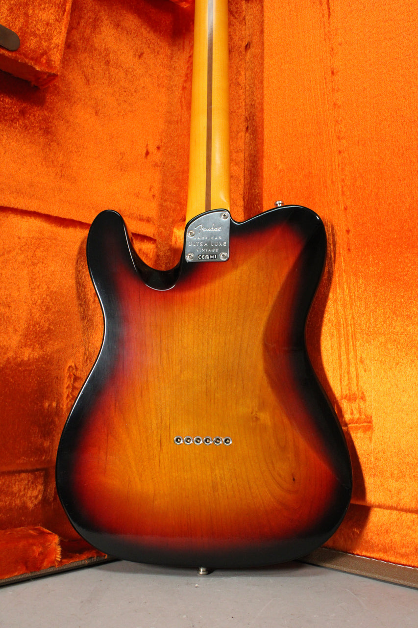 The guitar's back, in a glossy 3-color sunburst, shows six string-through-body ferrules and a chrome neck plate.