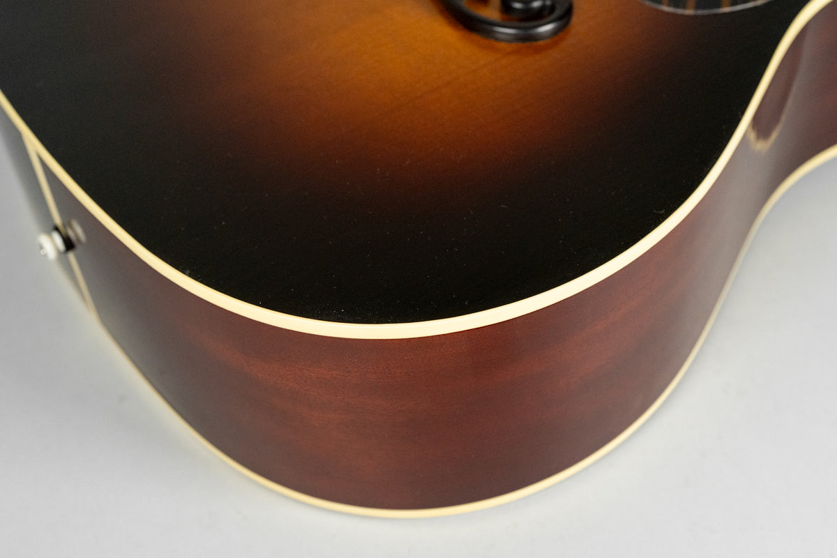 Close-up of the guitar's lower bout, showing the dark brown sunburst top, cream binding, and dark reddish-brown sides with a satin finish.