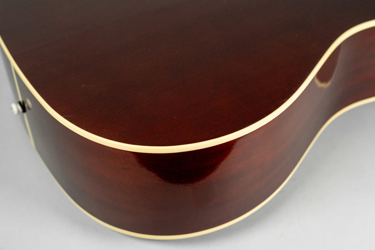 Close-up of the guitar's lower bout and side, showing the dark reddish-brown finish, cream binding, and a visible strap button.