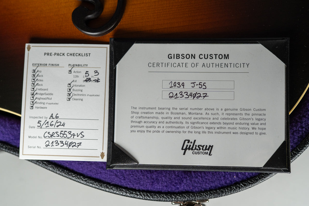 Close-up of the guitar's pre-pack checklist and certificate of authenticity, resting on purple velvet inside its open hard case.