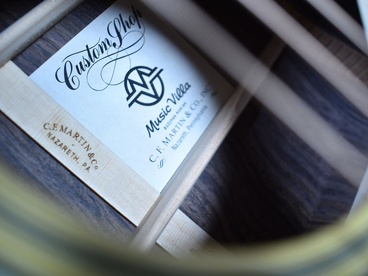 A close-up of the guitar's interior label, showing a white paper label with black script and block text, framed by light wood bracing.