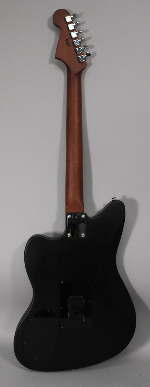 The black guitar is shown from the back, revealing a matte finish body, a natural wood neck, and six chrome tuners on the headstock.