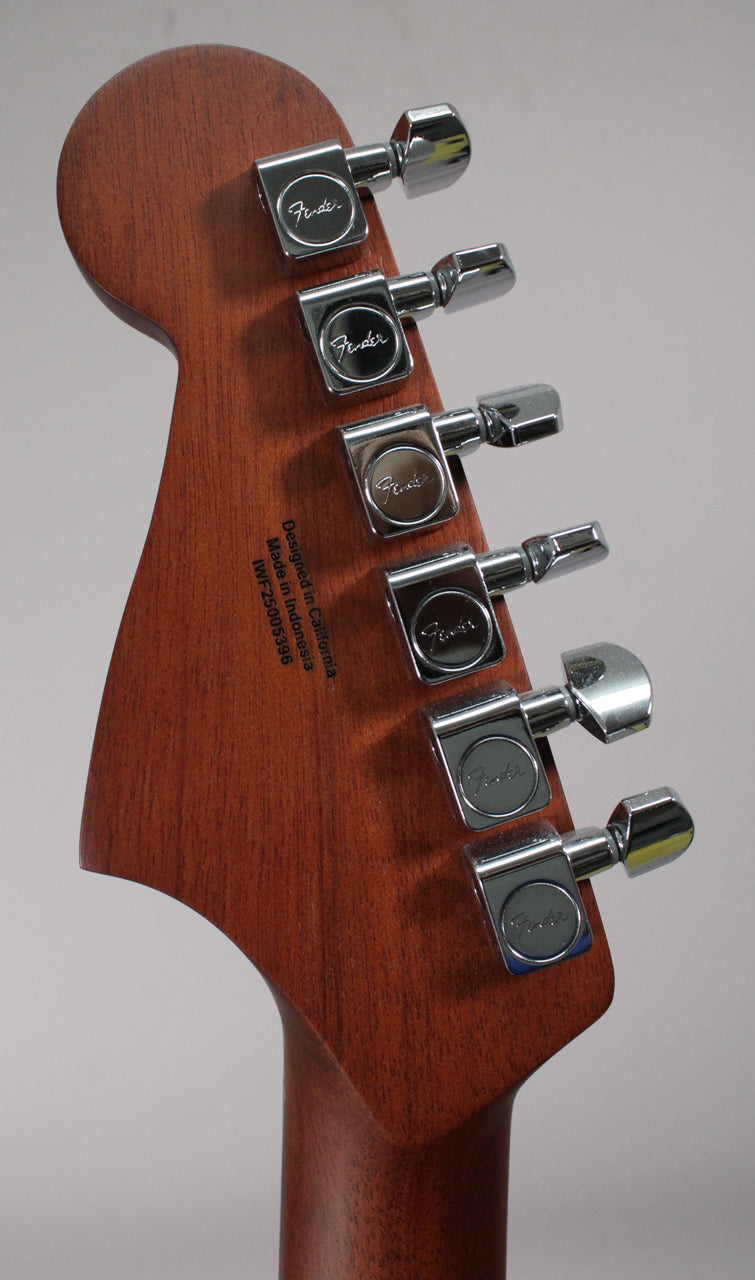 Angled view of the guitar's headstock and neck, showing the mahogany-stained wood grain and six chrome tuning machines.