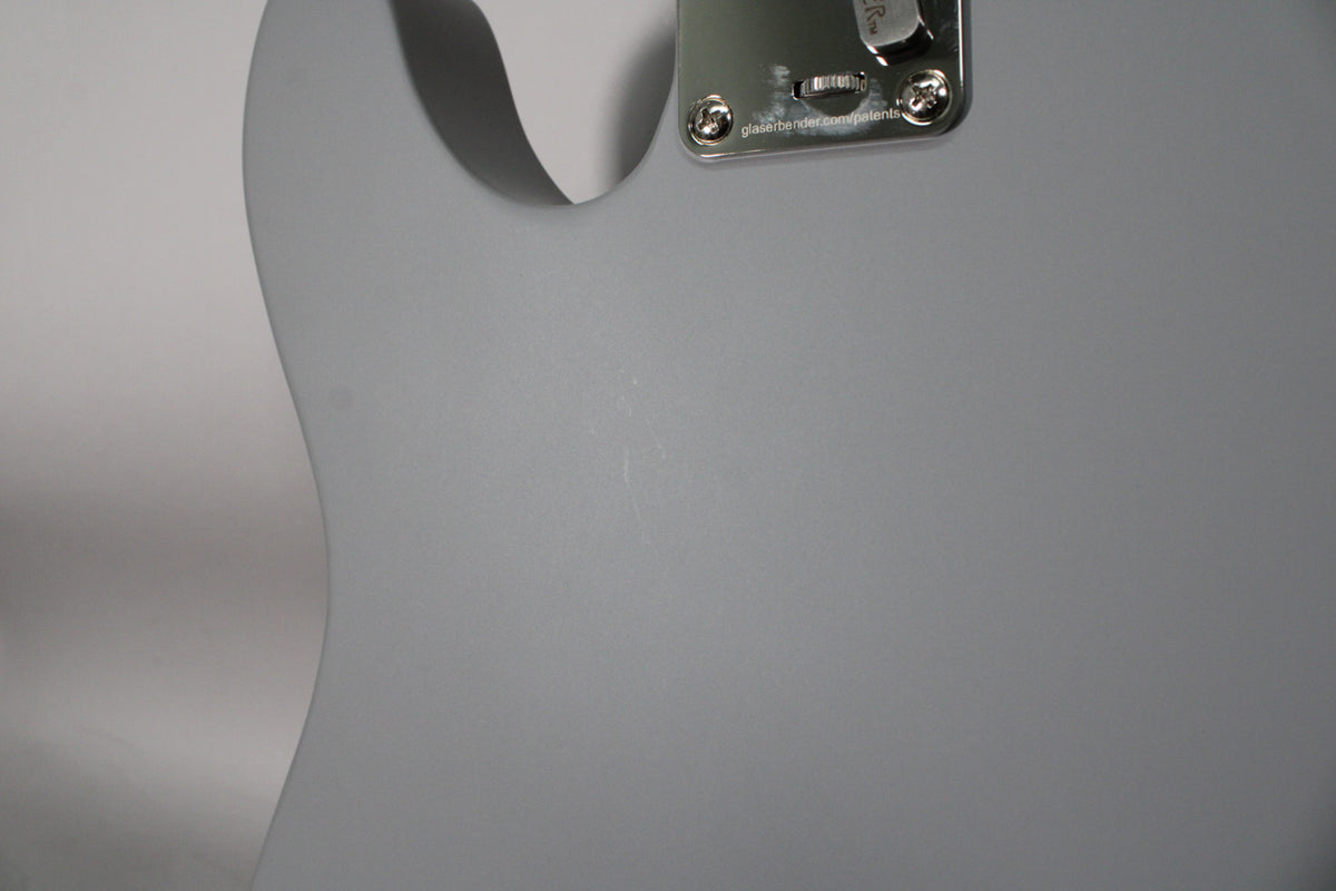 Close-up of the upper bout of a primer gray Telecaster, showing light surface scratches and a chrome B-Bender system.