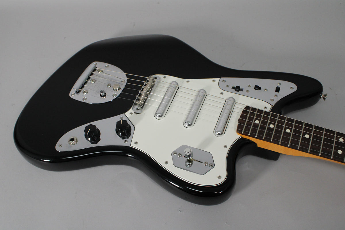 A black electric guitar with a white pickguard, chrome hardware, and a rosewood fretboard with dot inlays.