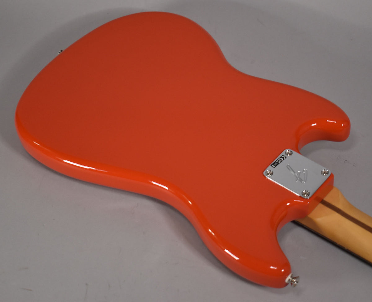 The glossy Rallye Orange bass body is shown from the back, angled to the right, with a chrome neck plate and strap button visible.