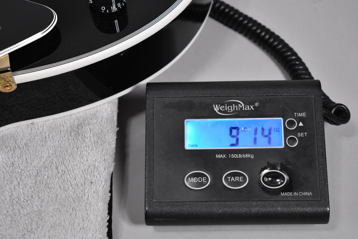 Close-up of the guitar's lower bout on a white towel, next to a digital scale displaying "9 LB 14 OZ".