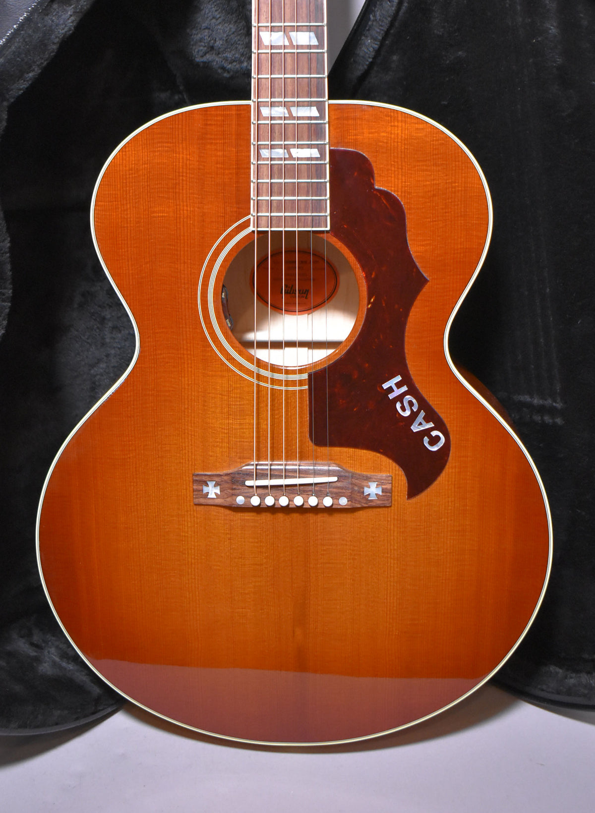 Full-front view of the cherry sunburst acoustic guitar, showing the "CASH" pickguard and cross-shaped bridge inlays.