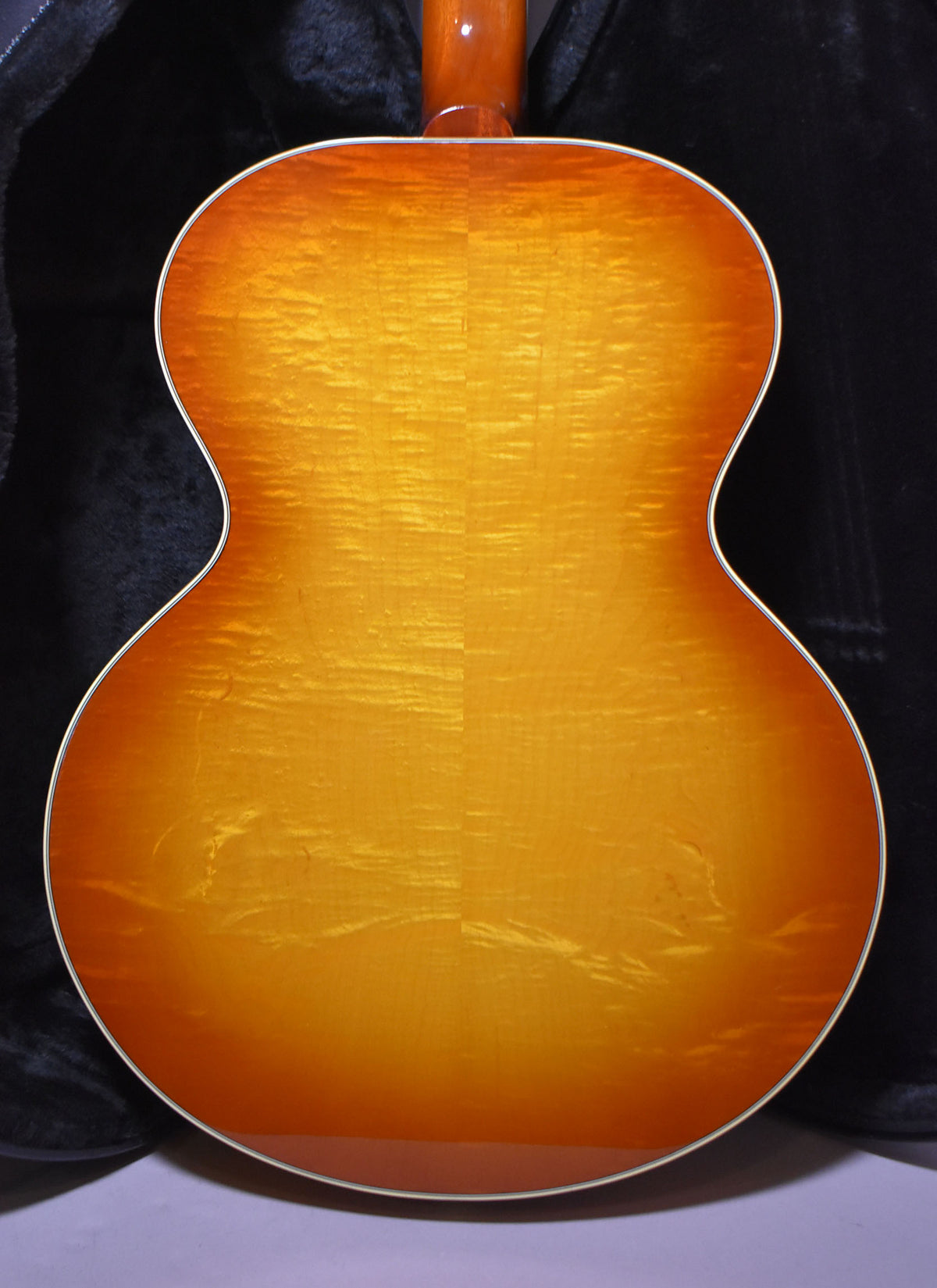 The guitar's cherry sunburst back shows prominent flame maple grain, with a light binding around the body.