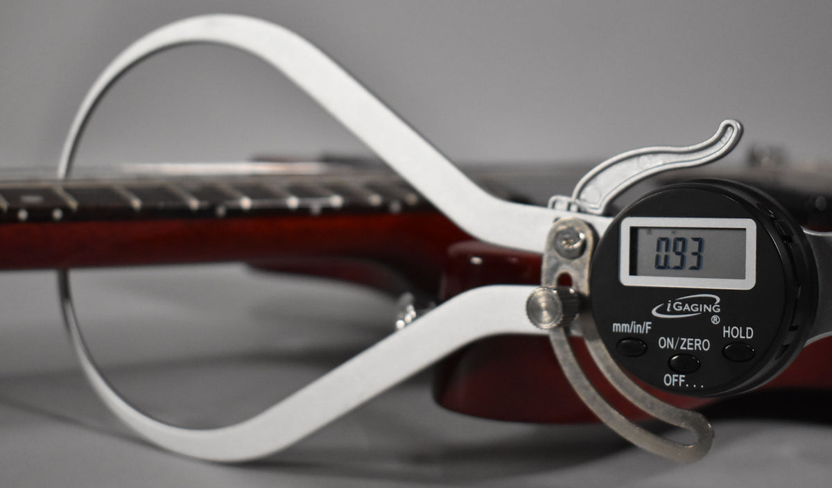A digital caliper measures the fret height on the vintage cherry neck, displaying 0.93mm.